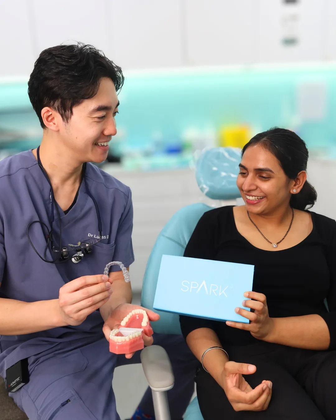 A dentist showing a patient a clear aligner at My Local Dentists West Ryde