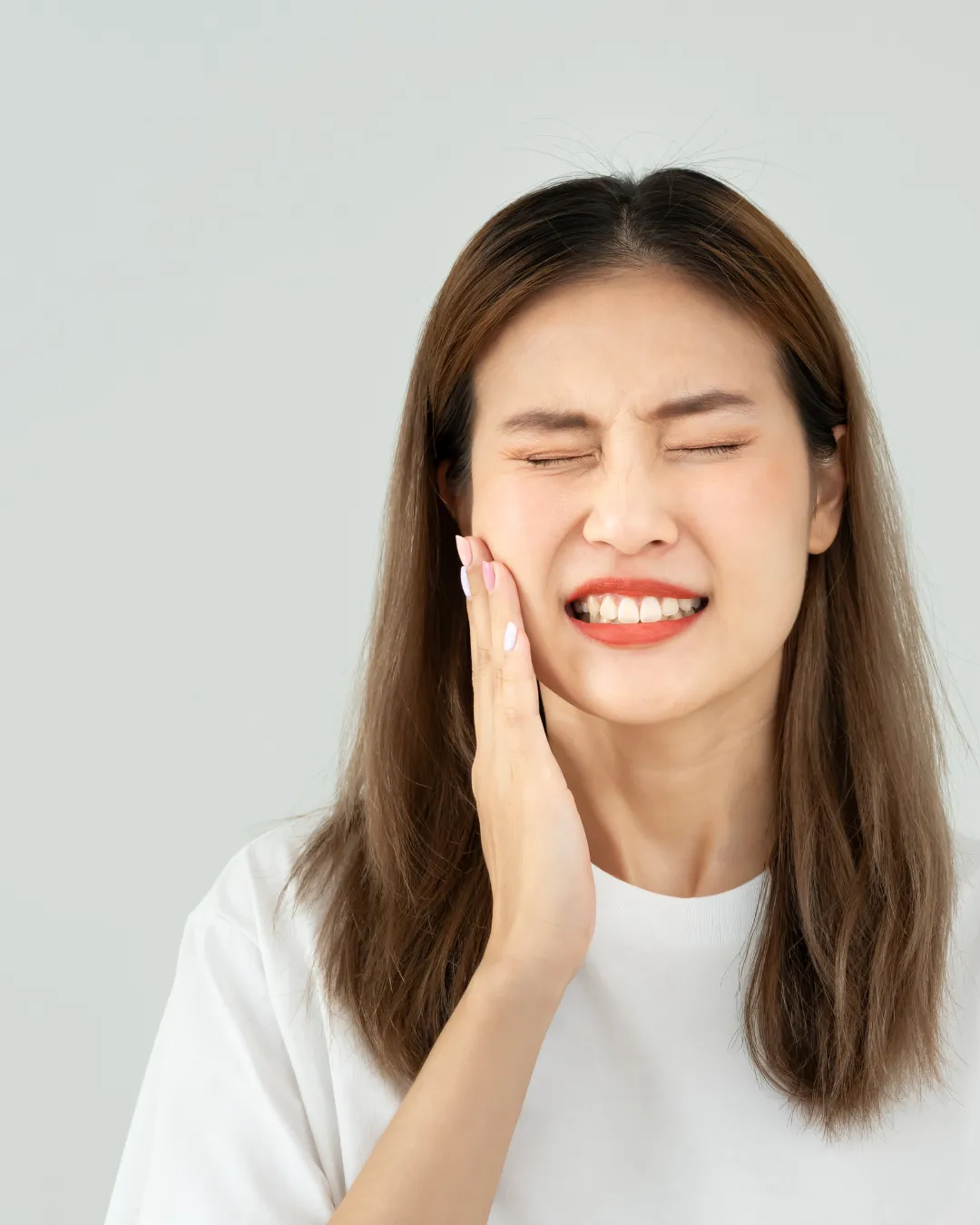 Person holding their jaw with severe toothache before an emergency dental appointment